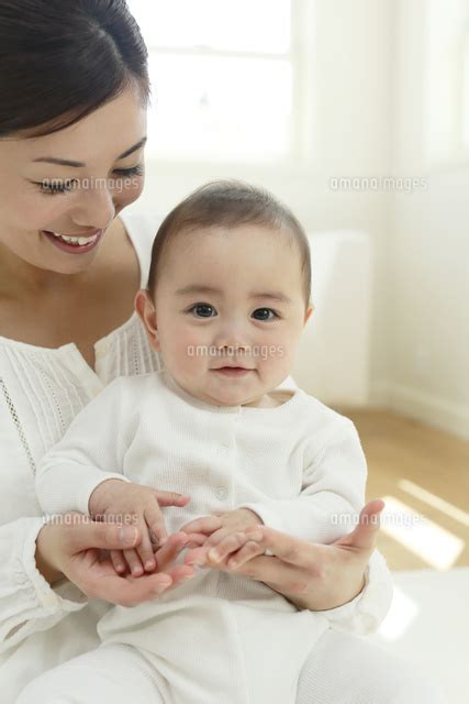 リビングでお母さんに抱っこされる赤ちゃん 11038023487 の写真素材・イラスト素材｜アマナイメージズ