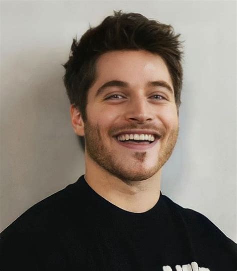 a man smiling and wearing a black shirt