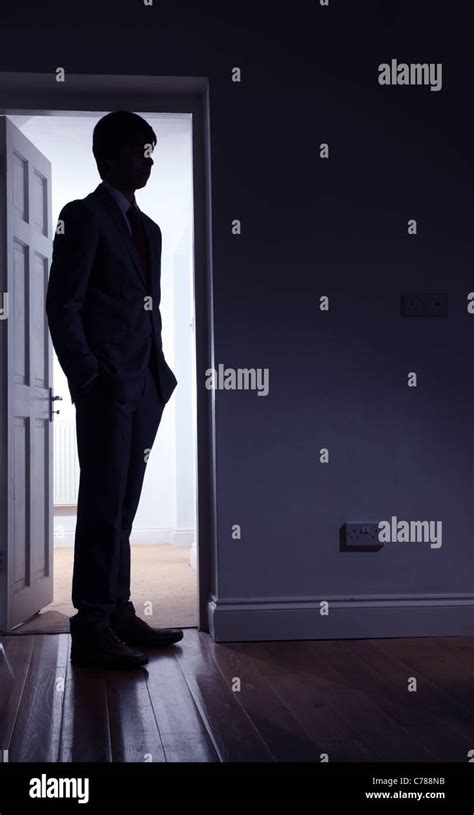 Silhouette Of A Man Standing In Front Of An Open Door Stock Photo