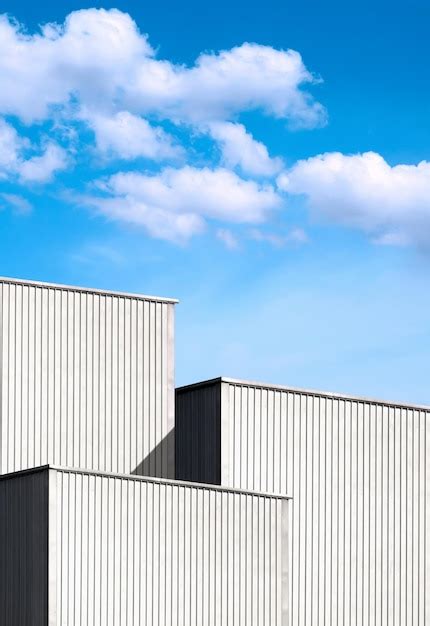 3 Naves Industriales De Metal Corrugado Contra Nubes Sobre Fondo De