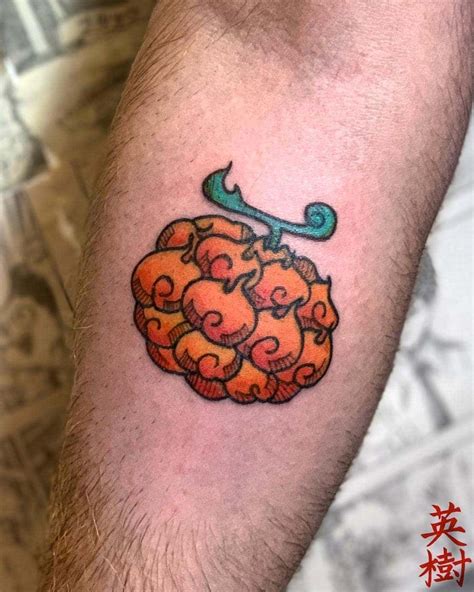 A Man S Arm With A Tattoo On It That Has An Orange And Blue Design