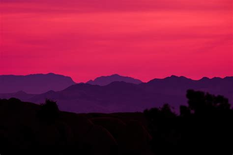 A pink and purple sky with mountains in the background photo – Free ...