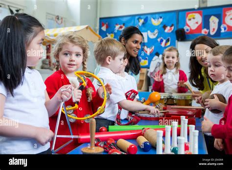 Nursery children playing with musical instruments in the classroom. One ...