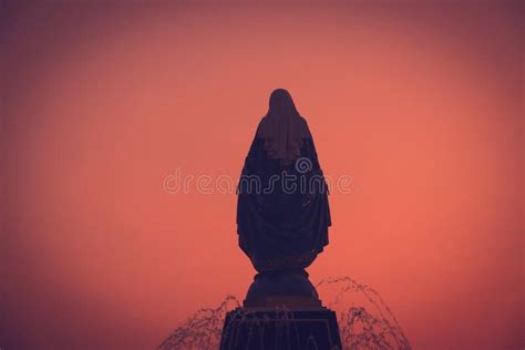 Silhouettes Of The Blessed Virgin Mary Statue Figure In A Warm Tone Sunset Scene Catholic