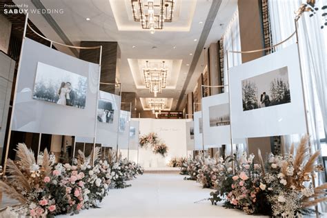 An Aisle Decorated With Flowers And Pictures On The Wall For A Wedding