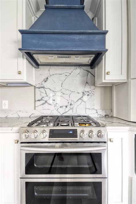 Navy Stained Island Hood Vent And Floating Shelves In White Shaker Kitchen Transitional