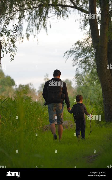 Father And His Son Walking Together Holding Hands Hi Res Stock