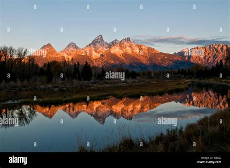 Teton Mountains in an autumn sunrise reflected in pond near ...