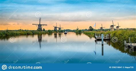 Historic Windmills And A River Flowing By In Kinderdijk Netherlands