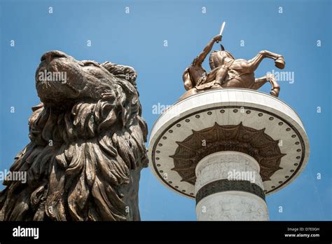 Estatua de Alejandro Magno con estatua de león en frente de ella en