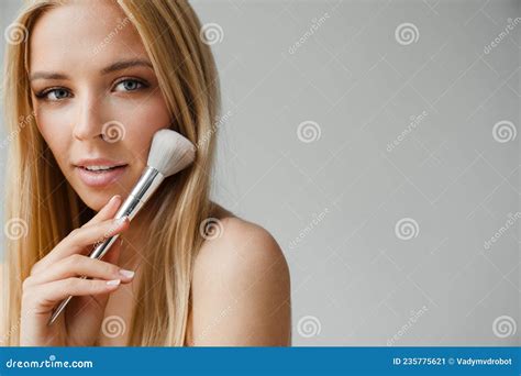 Half Naked Blonde Woman Looking At Camera While Using Powder Brush