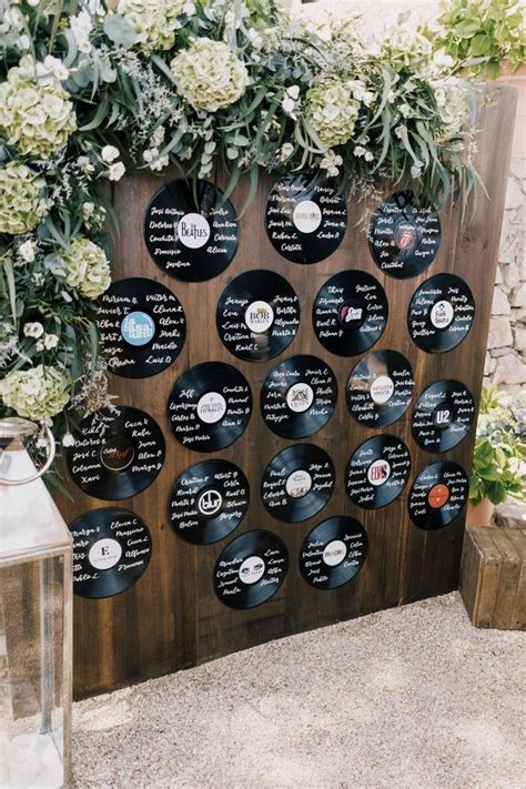 The Record Wall Is Decorated With White Flowers And Greenery For An