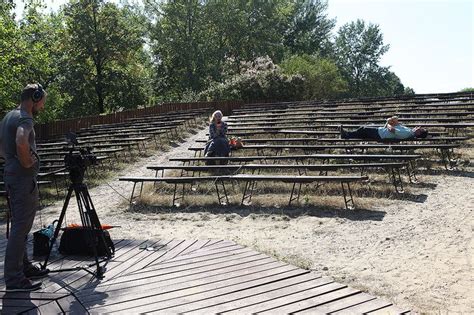 Some People Are Laying On Benches In The Sand And One Is Filming