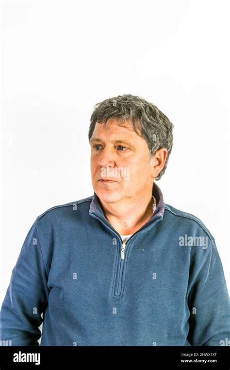 Man In Blue Sweater Poses In Front Of White Wall Stock Photo Alamy