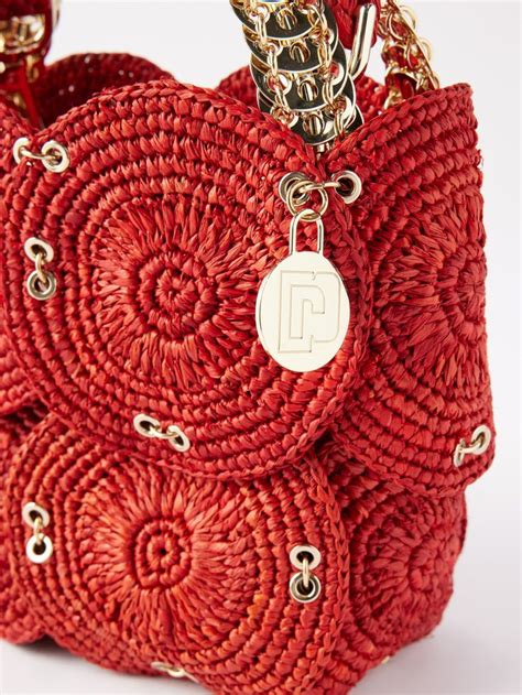 A Red Woven Purse With Gold Chains And A Chain Around The Handle On A