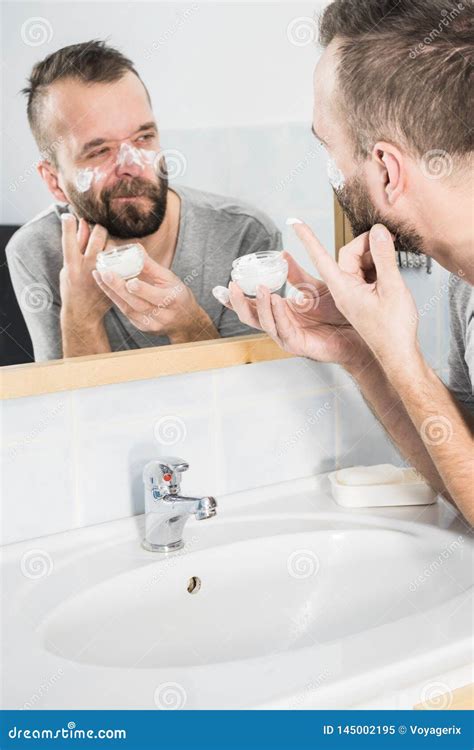 Man Applying Moisturizer Cream In Bathroom Obraz Stock Obraz Z O Onej