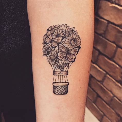 A Black And White Photo Of Flowers In A Vase Tattoo On The Left Inner Arm