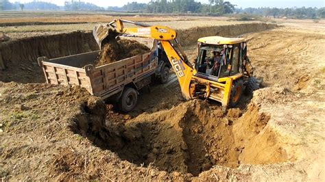 Jcb Earth Movers Cutting Soil And Loading In Dump Truck Dump Truck