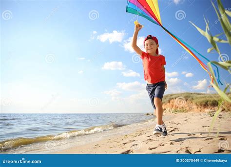 Cute Little Child With Kite Running On Beach Near Sea Spending Time In