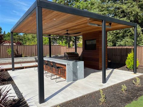 A Covered Outdoor Kitchen Area With Bar Seating