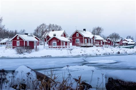 Premium Photo | Red wooden houses on the bank of a frozen lake in winter ohtakari finland