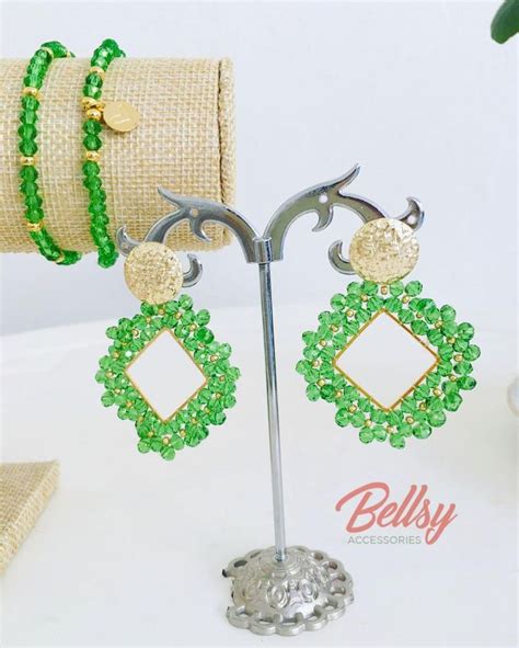 A Pair Of Green And Gold Beaded Earrings With Matching Bracelets Are On