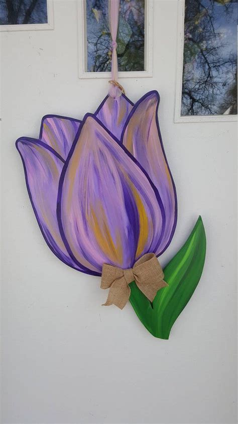 A Purple Tulip Hanging On The Side Of A White Wall Next To Three Windows