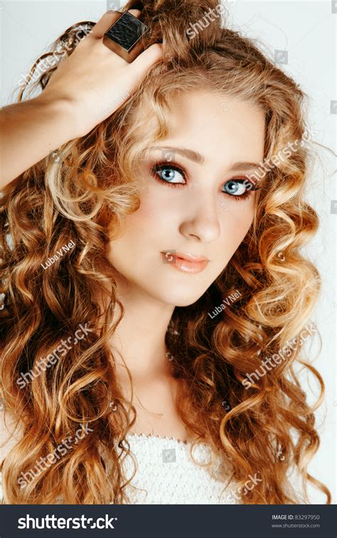 Beautiful Strawberry Blond Woman With Blue Eyes And Long Big Curly Hair With Hand In Hair Stock