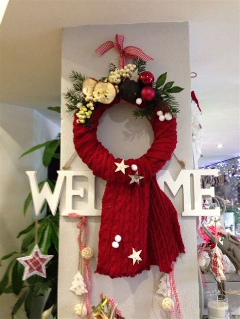 A Christmas Wreath Hanging On The Side Of A Wall Next To A Sign That