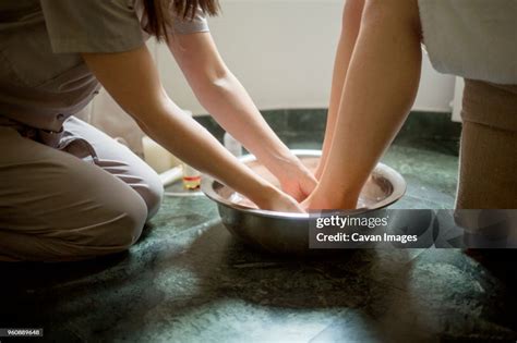 Midsection Of Therapist Giving Foot Massage To Woman In Spa High Res