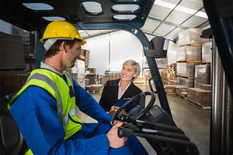 Encargado De Warehouse Que Habla Con El Conductor De La Carretilla