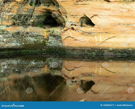 A Landscape With A Steep River And Caves On A Sandstone Cliff Stock