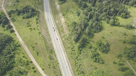 Countryside road surrounded by lush green nature. Clip. Top view of
