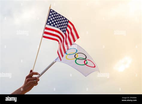 Fan Waving The National Flag Of Usa And The Olympic Flag With Symbol