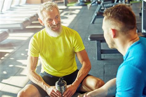 Hombre Positivo De Mediana Edad Con Ropa Deportiva Sosteniendo Una