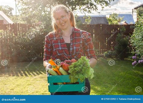 Female Farmer Carrying Box Of Picked Vegetables Garden And Harvesting