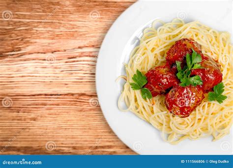 Massa Dos Espaguetes Os Tomates Na Tabela De Madeira Foto De Stock