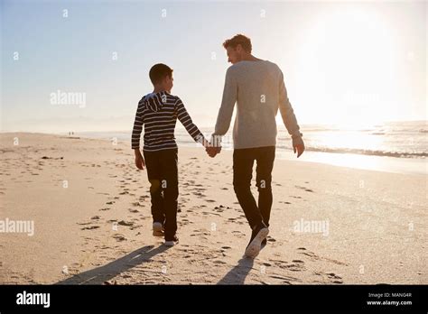 Vista Trasera De Padre E Hijo Caminando Por La Playa De Invierno De La