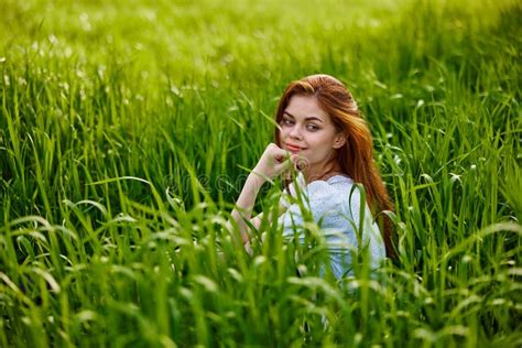 Beautiful Redhead Woman Relaxing Sitting In Tall Grass Stock Image