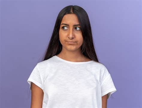 Chica Joven En Camiseta Blanca Mirando A Un Lado Con Cara Seria De Pie