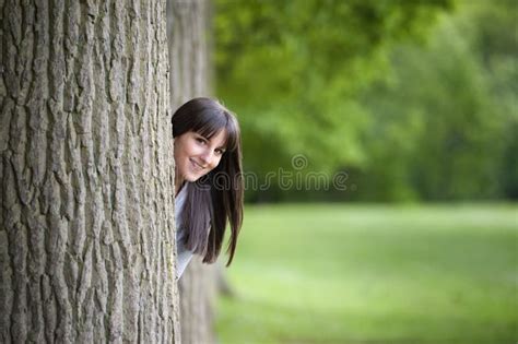 Het Jonge Vrouw Verbergen Achter Een Boom Stock Foto Image Of