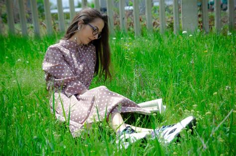 Una Mujer Linda Sentada En La Hierba Chica Leyendo Un Libro En El