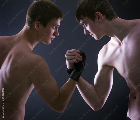 Two muscular men fighting on a dark background. Stock Photo | Adobe Stock