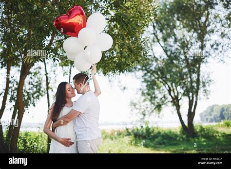 Happy And Young Pregnant Couple Hugging In Nature Romantic Moments