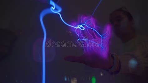 Hand Touching Plasma Ball With Blue Violet Electric Lightning In Lab