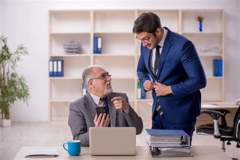 Jefe Masculino Viejo Y Empleado Joven En La Oficina Foto De Archivo