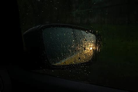 Premium Photo | Car side mirror with headlight reflection in rain