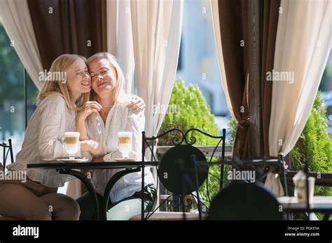 Portrait of smiling mature belle mère et sa fille boire du café assis à la maison La famille