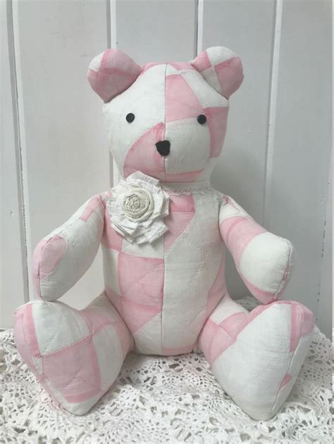 A Pink And White Teddy Bear Sitting On Top Of A Table