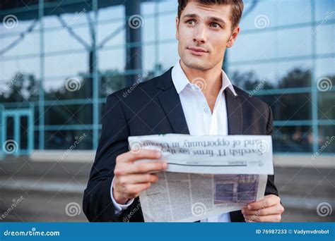 Portrait Of A Handsome Businessman Holding Newspaper Outdoors Stock